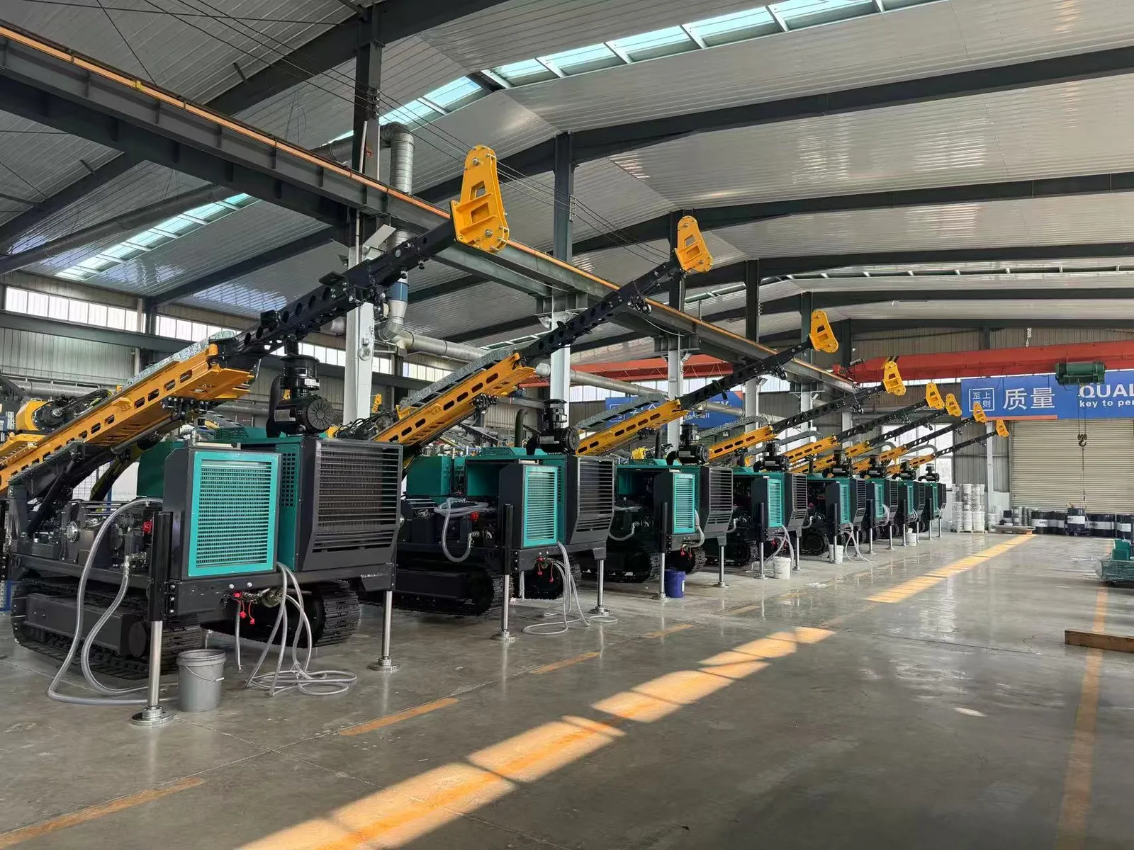 Assembly hall at the Jining factory with a row of crawler core drilling rigs on the production floor